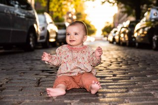 Baby on cobbled West Village Street in afternoon light